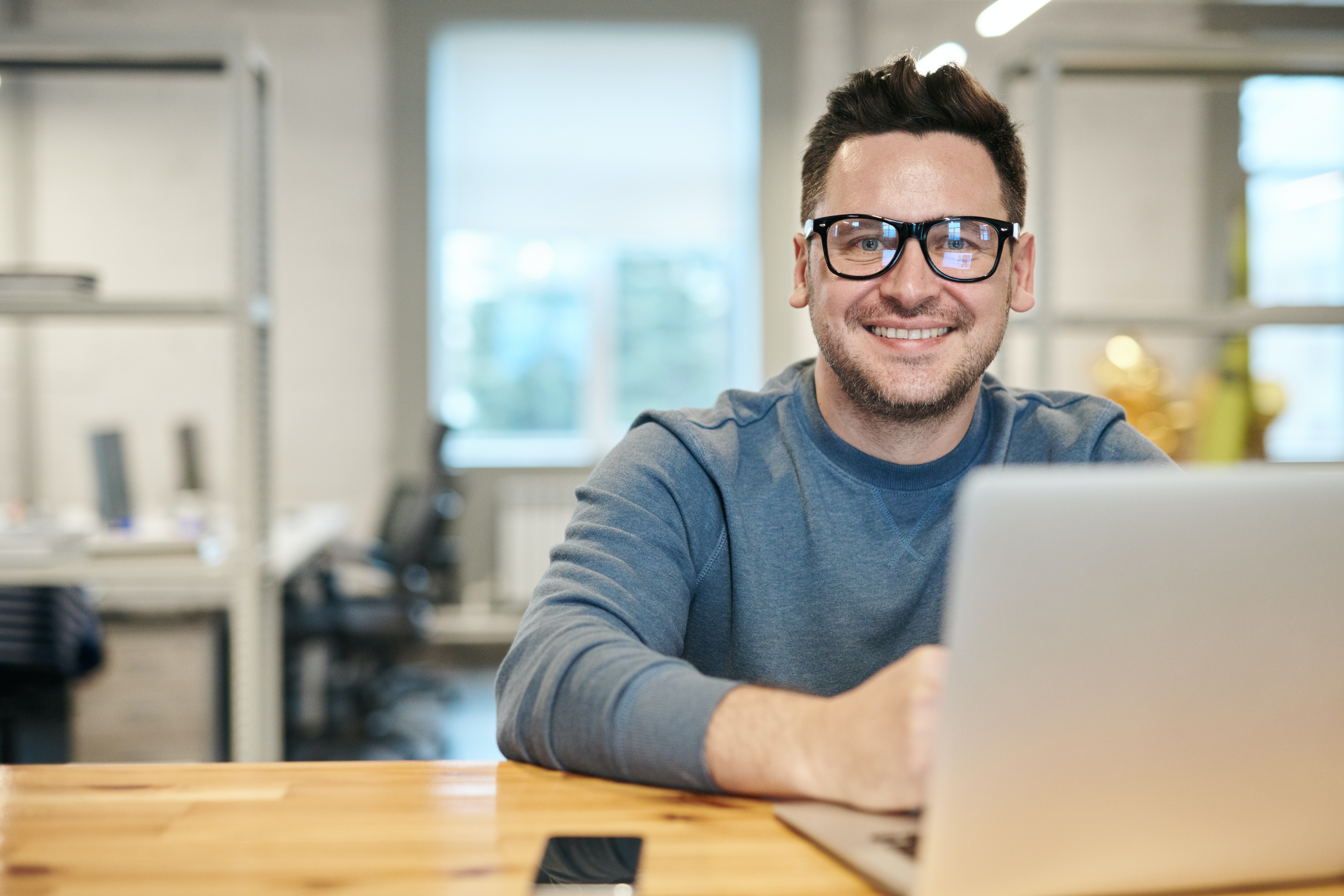 Man wearing glasses using a laptop